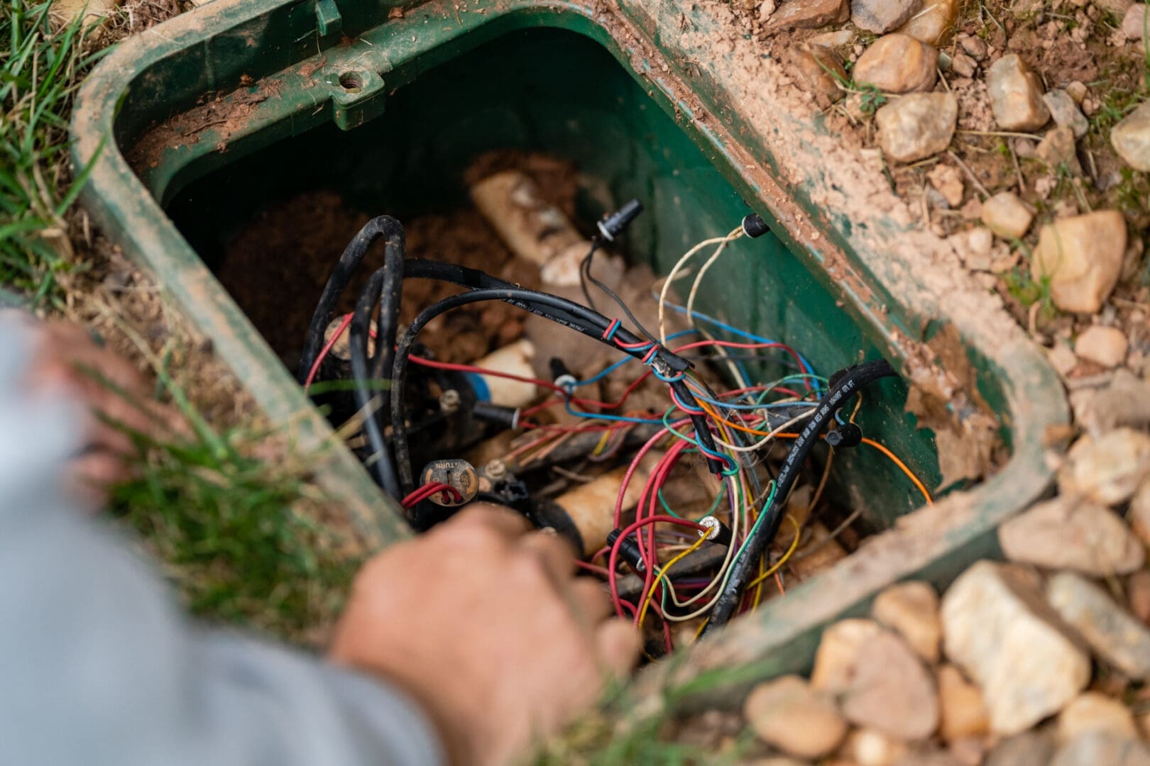 Open ground utility box with exposed wires