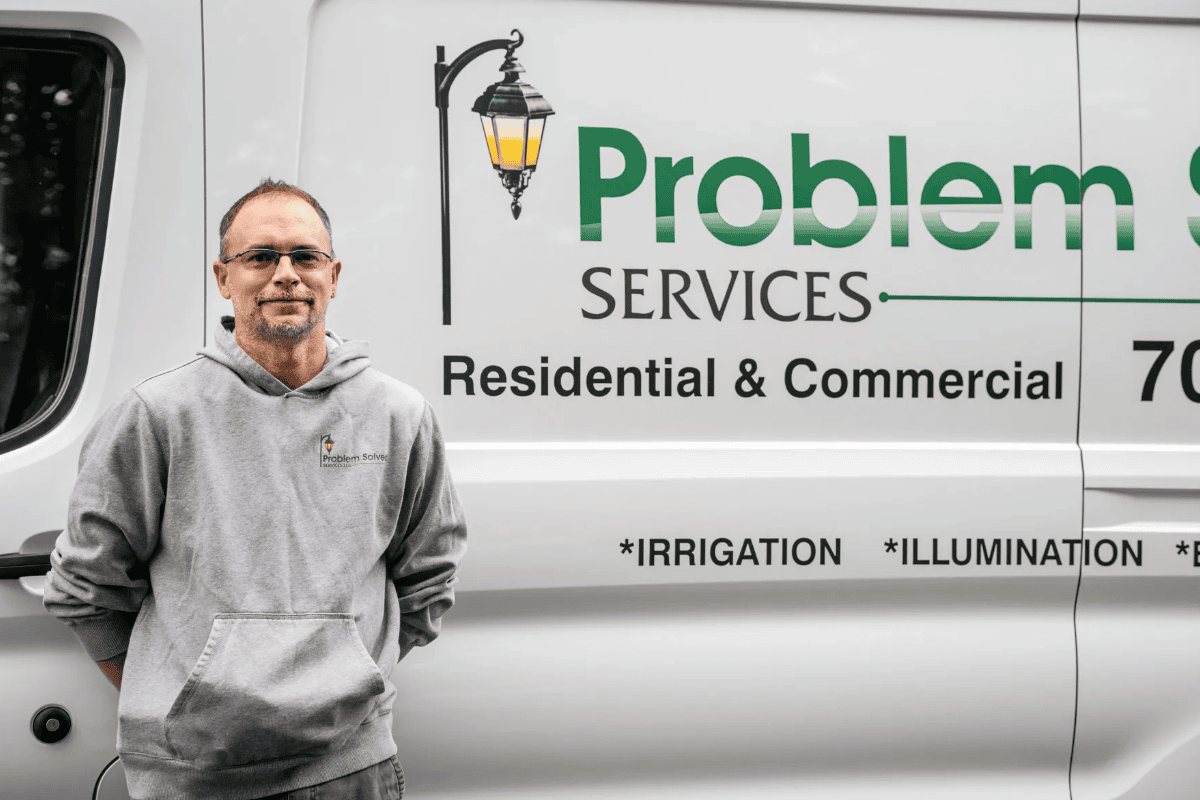 Technician standing beside residential and commercial van