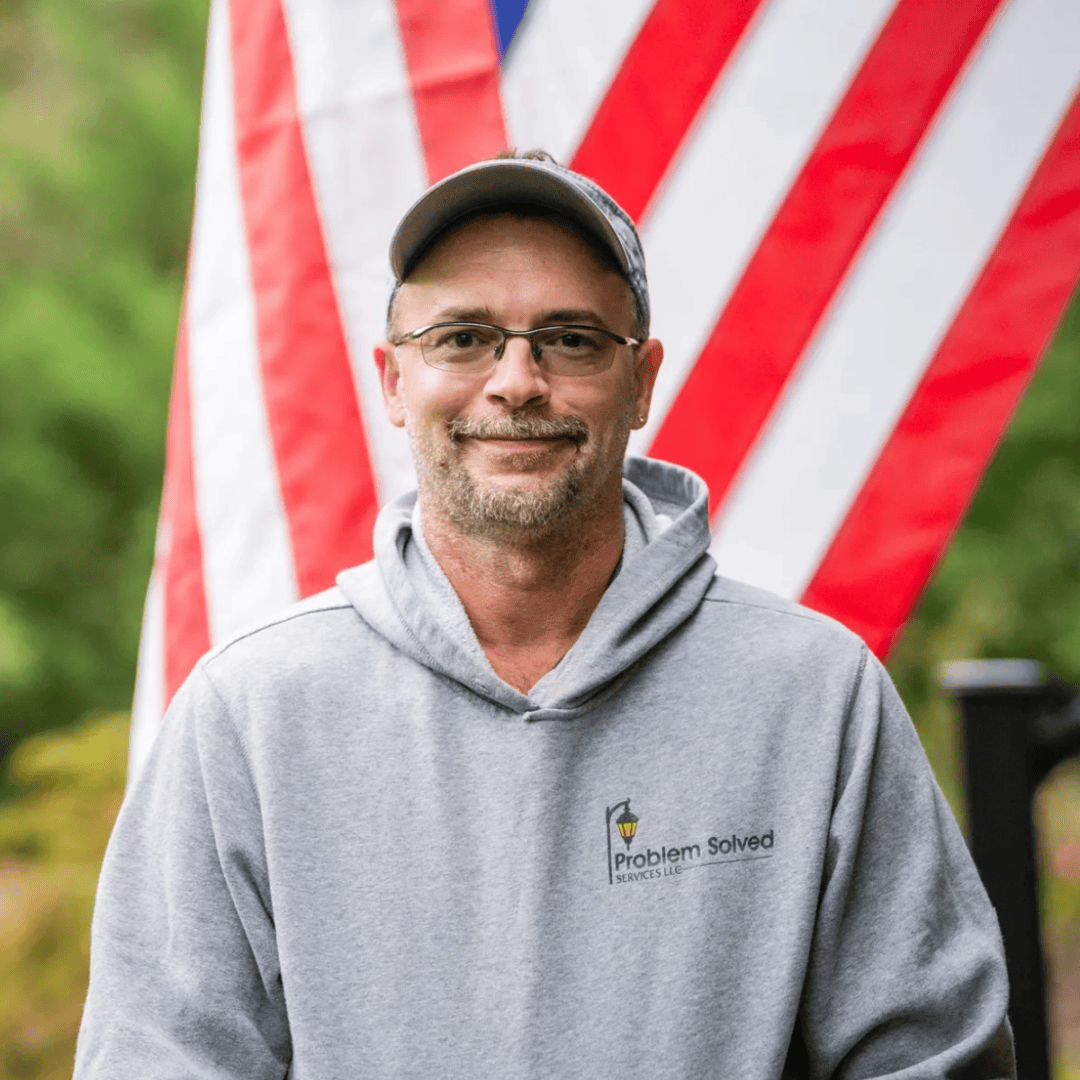 Smiling man in hoodie before American flag